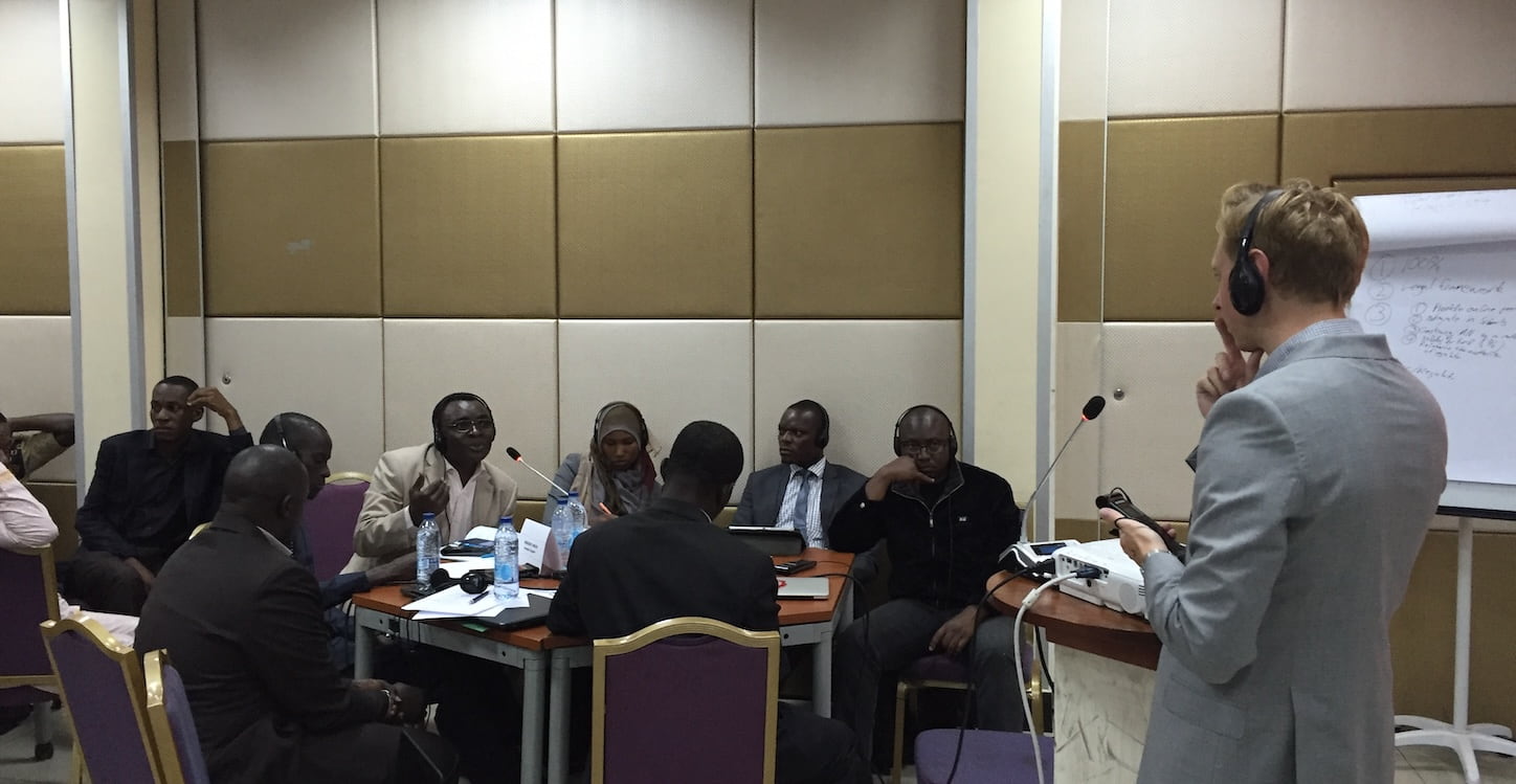 A man in a suit presents to an attentive audience