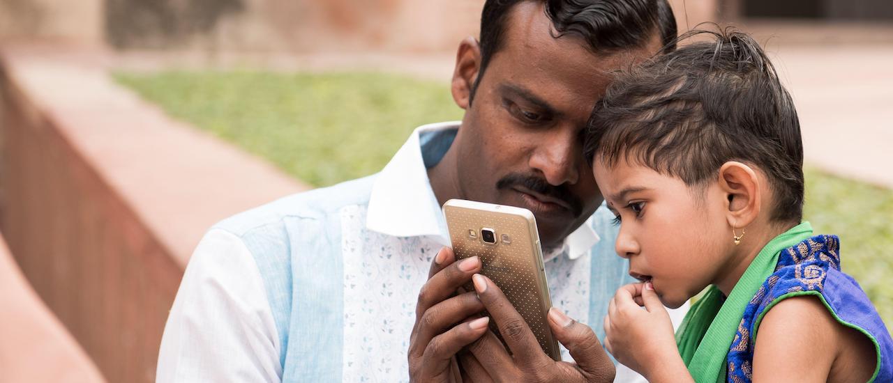 Indian father and child with smartphone